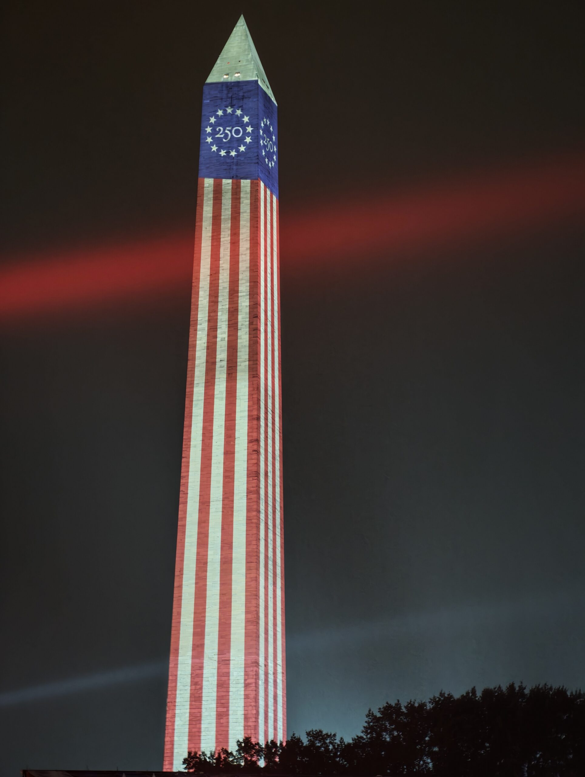 Das Washington Monument nachts mit Flaggenprojektion