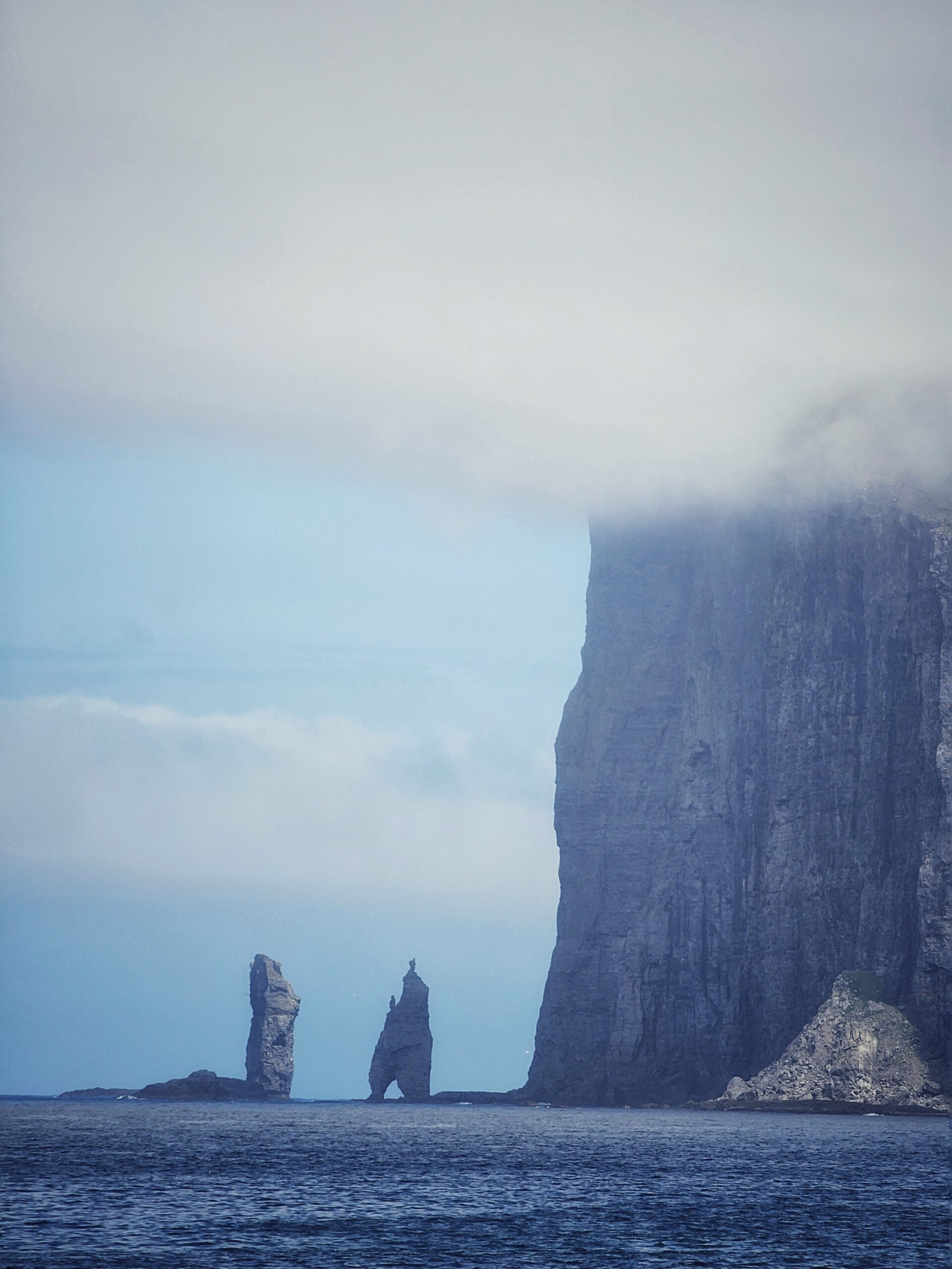 Steilwand mit zwei Felsnadeln im Nebel