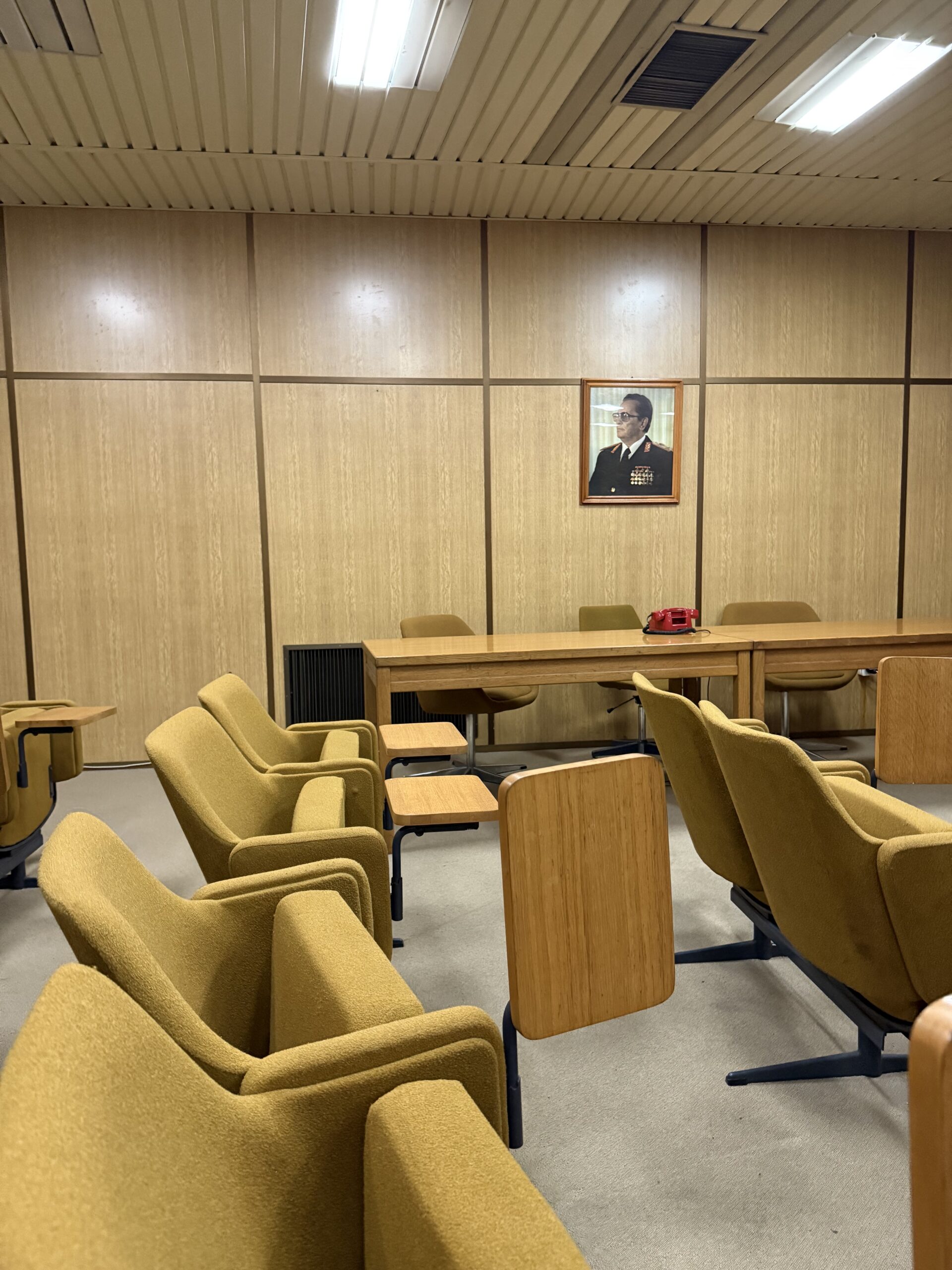 Konferenzraum mit gelben Sesseln und Tito-Porträt im Bunker
