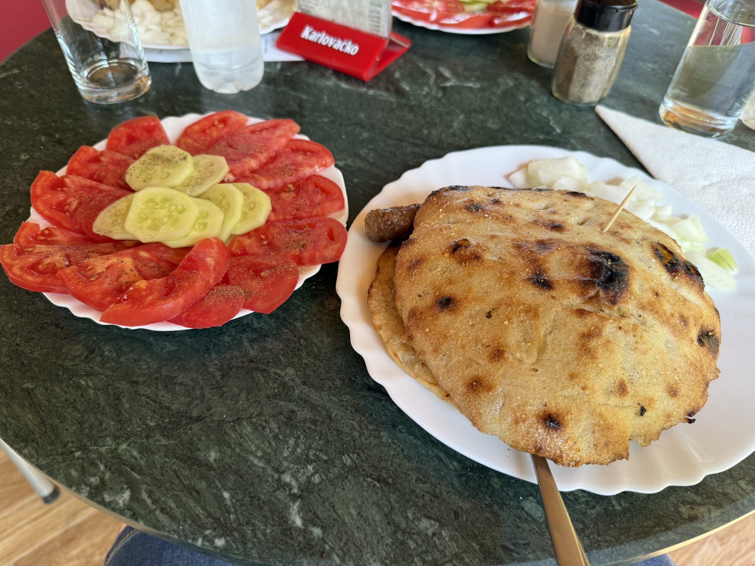 Ćevapi im Brotfladen mit Tomaten und Gurken